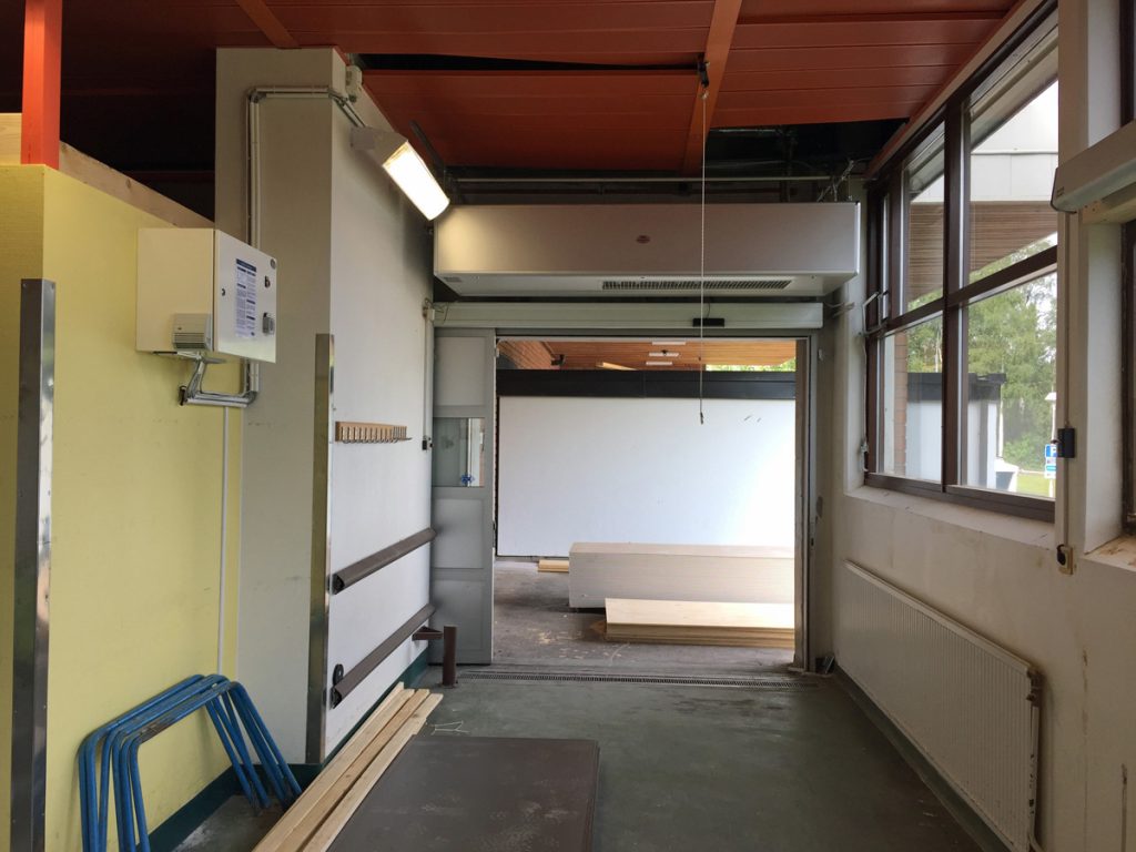 En ovanblåsande luftridå från RMK i en entré med fönster.