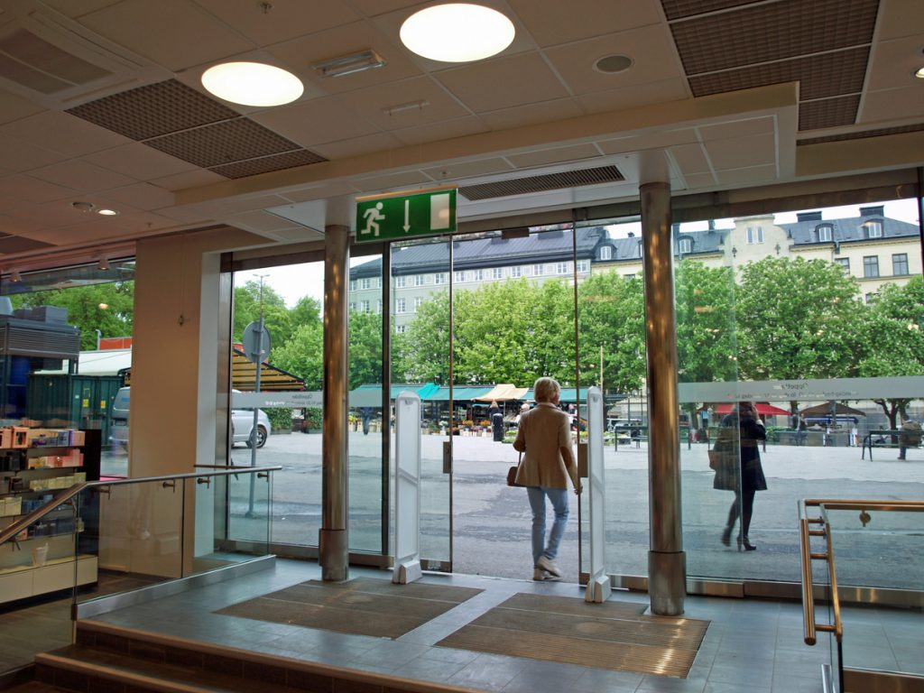 En sidoblåsande luftridå från RMK i en entré med torg utanför.