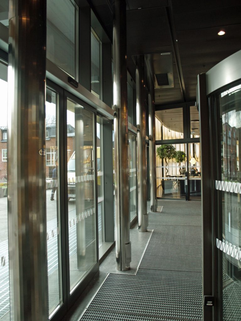 En sidoblåsande luftridå från RMK i en entré med gallergolv.