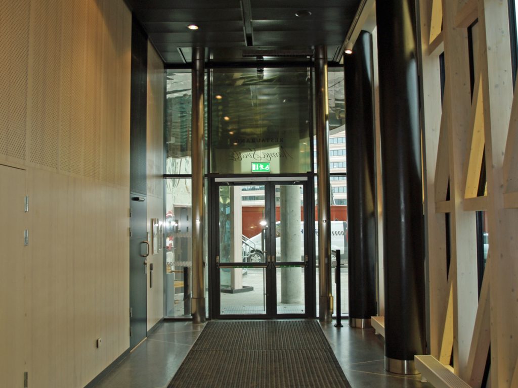 En sidoblåsande luftridå från RMK i en entré med träpanel.