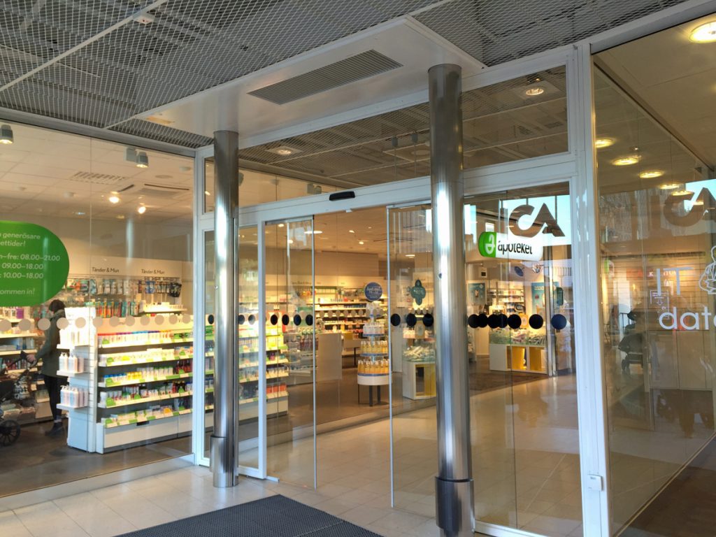 En sidoblåsande luftridå från RMK i en entré med glasdörr.