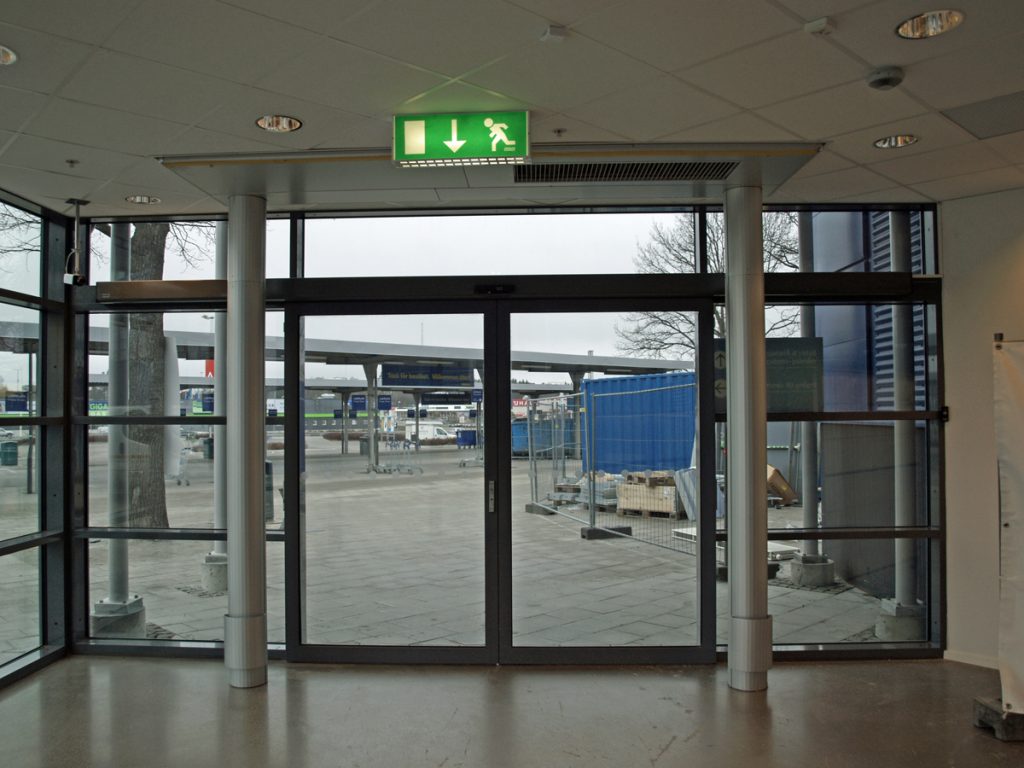 En sidoblåsande luftridå från RMK i en entré med blå bod.