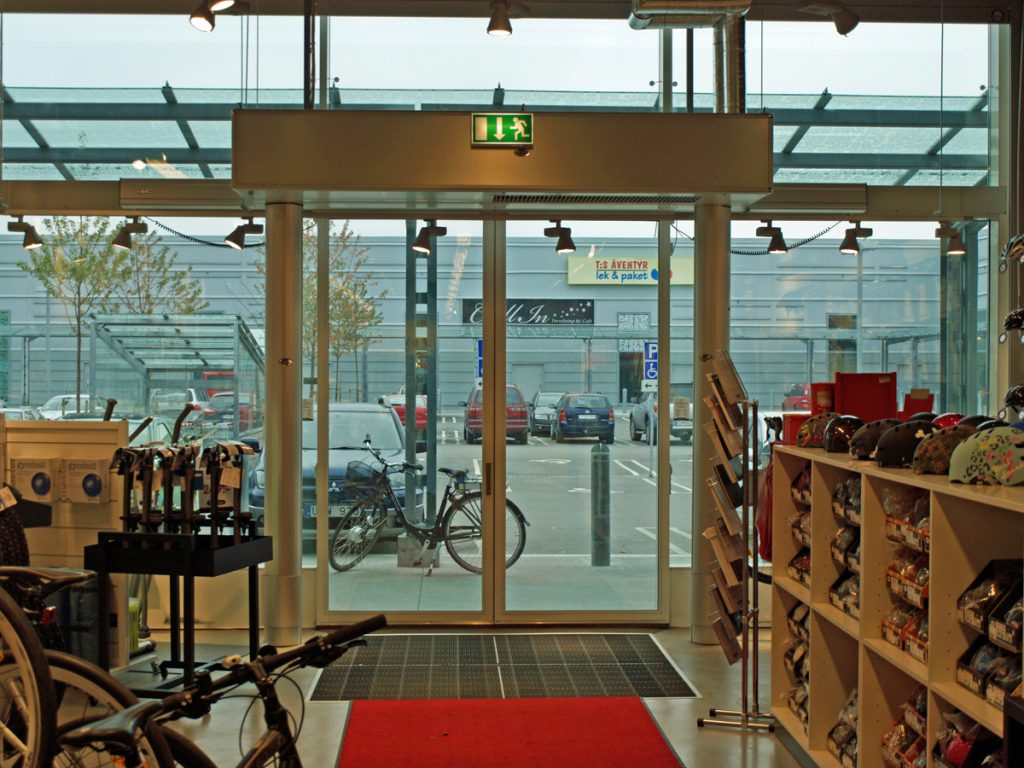 En sidoblåsande luftridå från RMK i en entré med cykel.