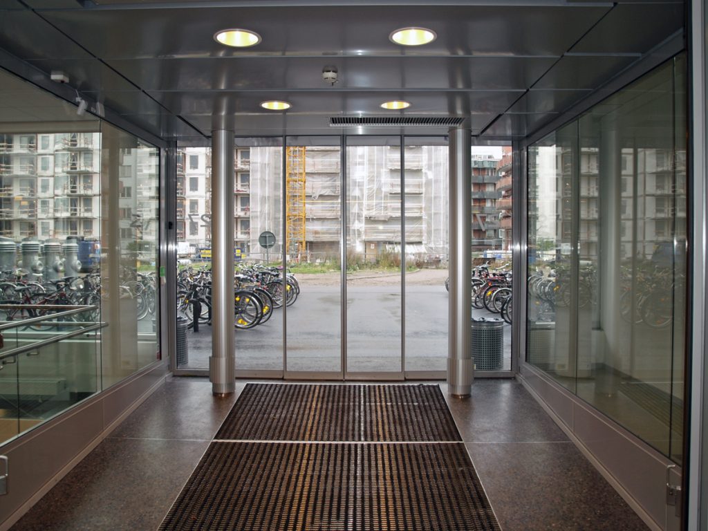 En sidoblåsande luftridå från RMK i en entré med cyklar.