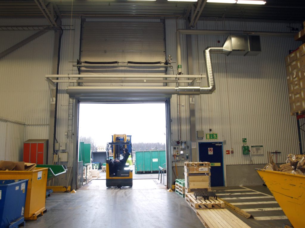 En ovanblåsande luftridå från RMK på industriport med truck som kör igenom.