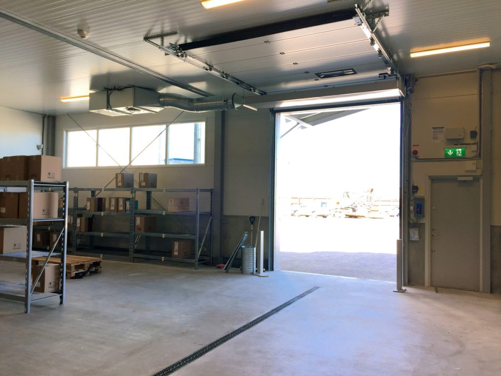 En ovanblåsande luftridå från RMK på industriport med svart rand i mitten.