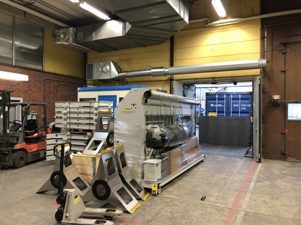 En ovanblåsande luftridå från RMK på industriport med gul vägg.