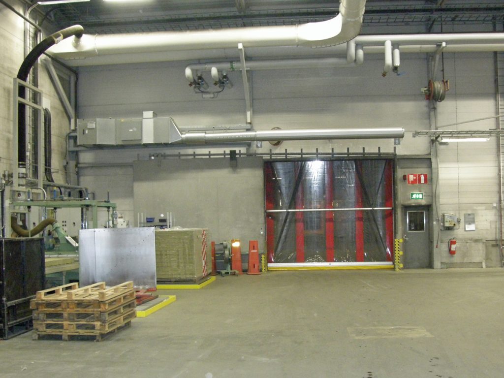 En ovanblåsande luftridå från RMK på industriport med pallar.