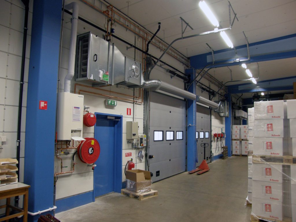 En ovanblåsande luftridå från RMK på industriport med lådor.