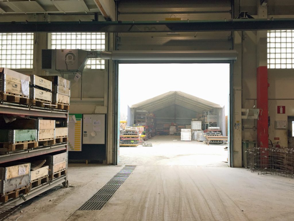 En ovanblåsande luftridå från RMK på industriport med hylla bredvid.
