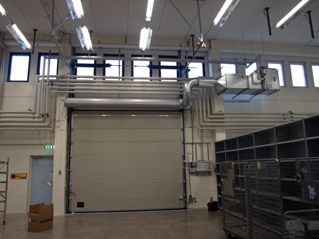 En ovanblåsande luftridå från RMK på industriport med rördragning.