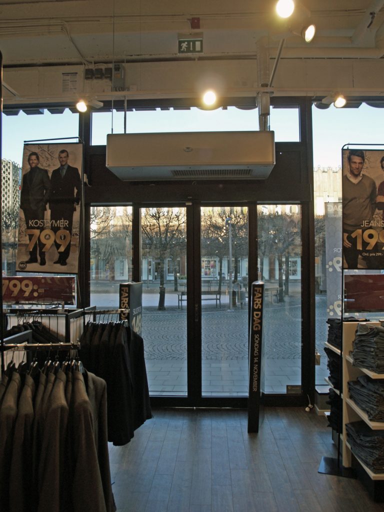 En ovanblåsande luftridå från RMK i en entré med kläder.