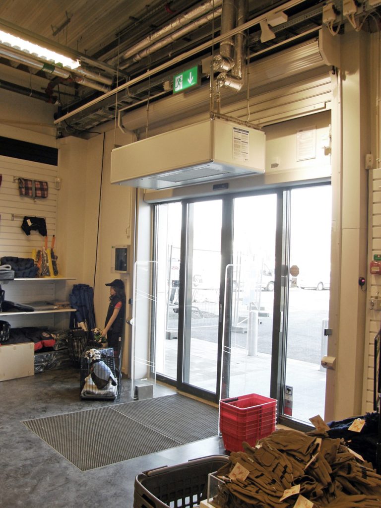 En ovanblåsande luftridå från RMK i en entré med röd korg.