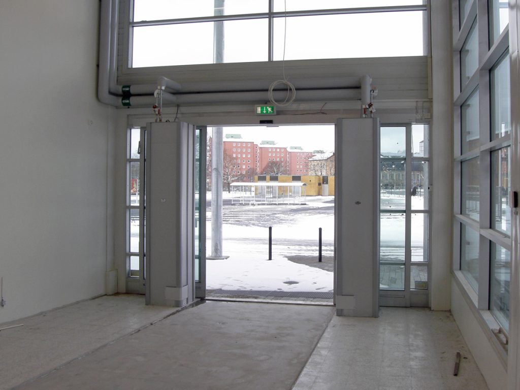 Sidoblåsande luftridåer från RMK i en entré med betonggolv.