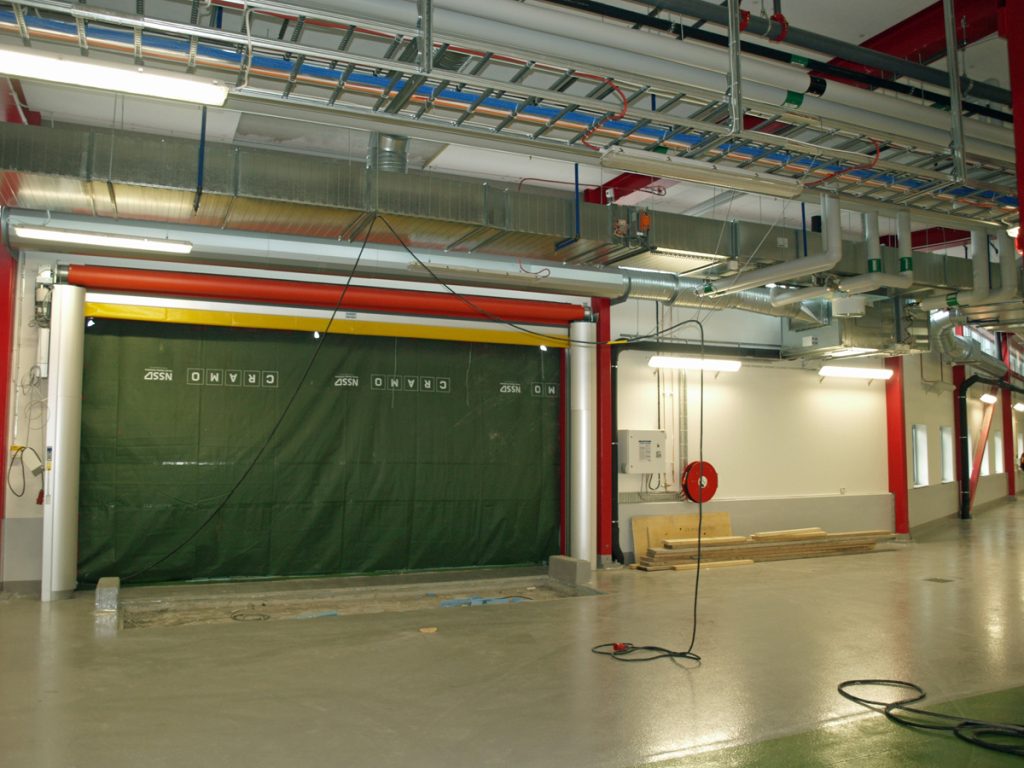 En ovanblåsande luftridå från RMK på industriport med grön pressenning.