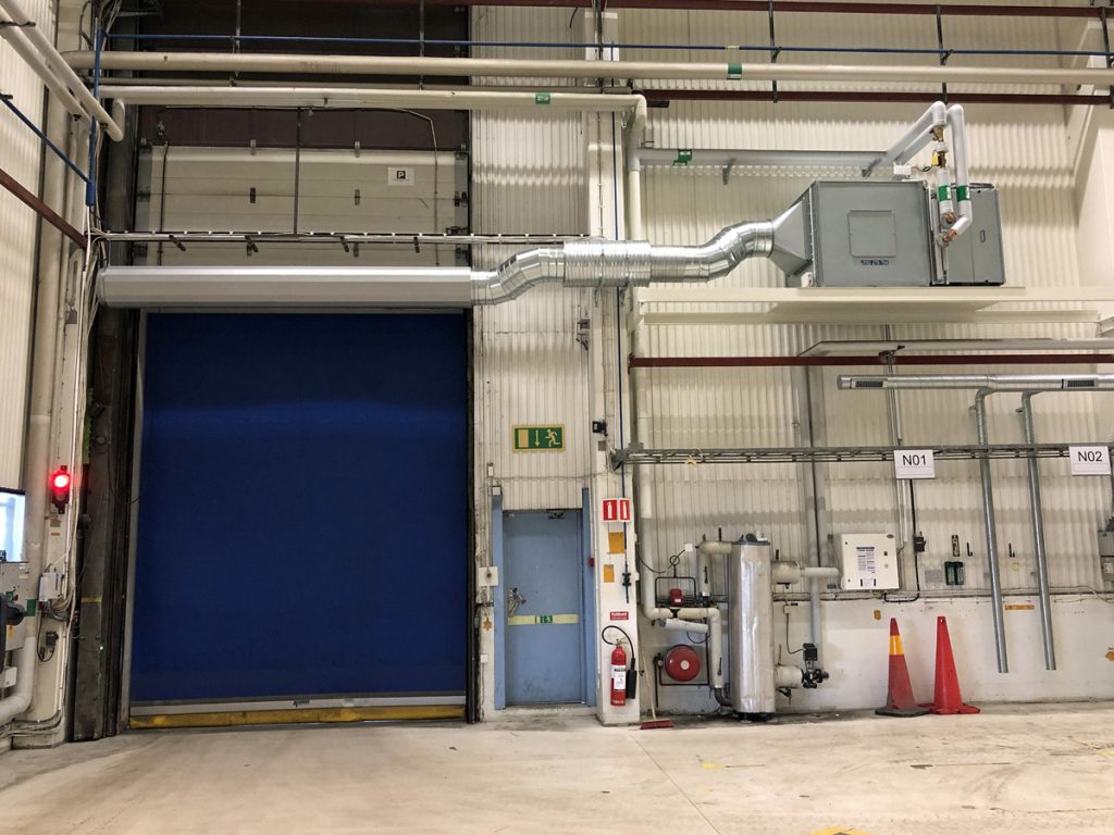 En ovanblåsande luftridå från RMK på industriport med koner.