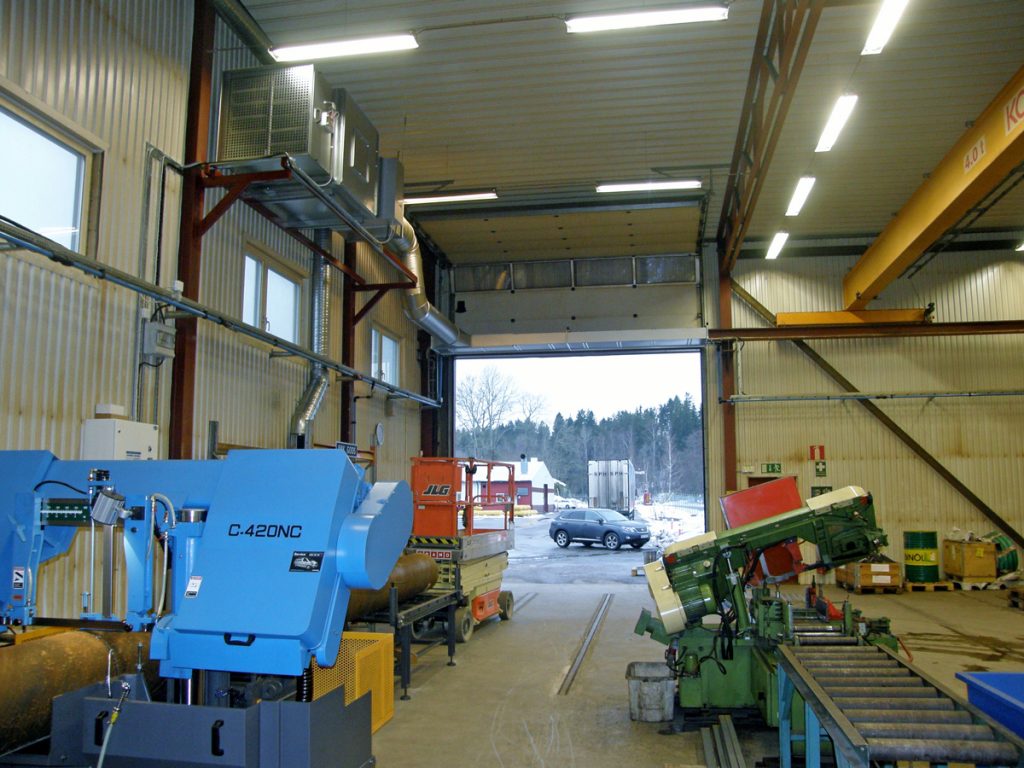 En ovanblåsande luftridå från RMK på industriport med gul travers.