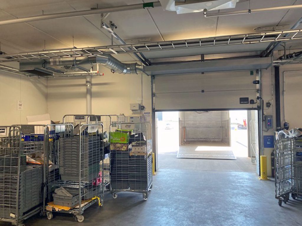 Ovanblåsande luftridå på ett kylrum med rullcontainers.