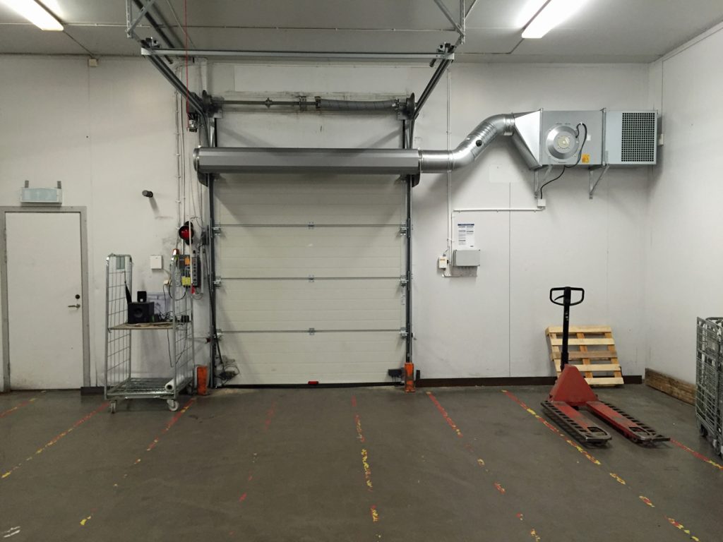 Ovanblåsande luftridå på ett kylrum med vita väggar.