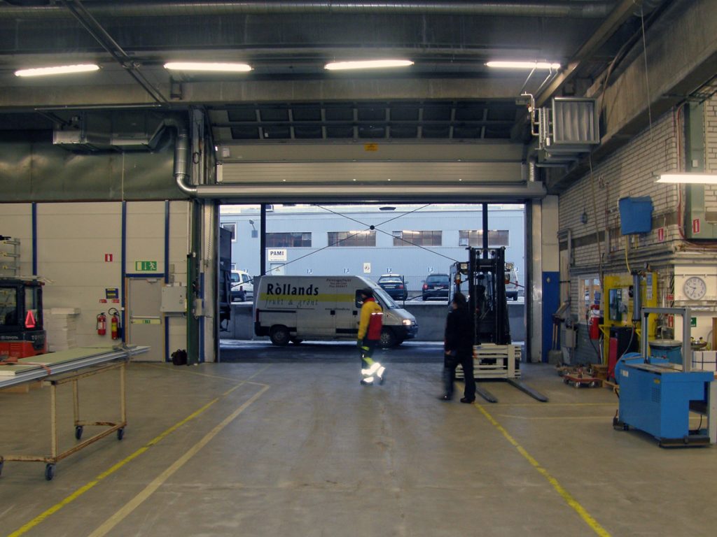 En ovanblåsande luftridå från RMK på industriport med vit skåpbil.